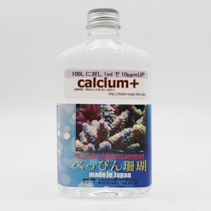 Bottle of calcium+ aquarium supplement with coral image label and 'made in Japan' text on blue design/photoContains blue coral graphic and Japanese labeling.