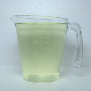 Clear measuring cup with a handle, filled with pale yellow liquid up to about the 600–700 ml marks visible on the side.